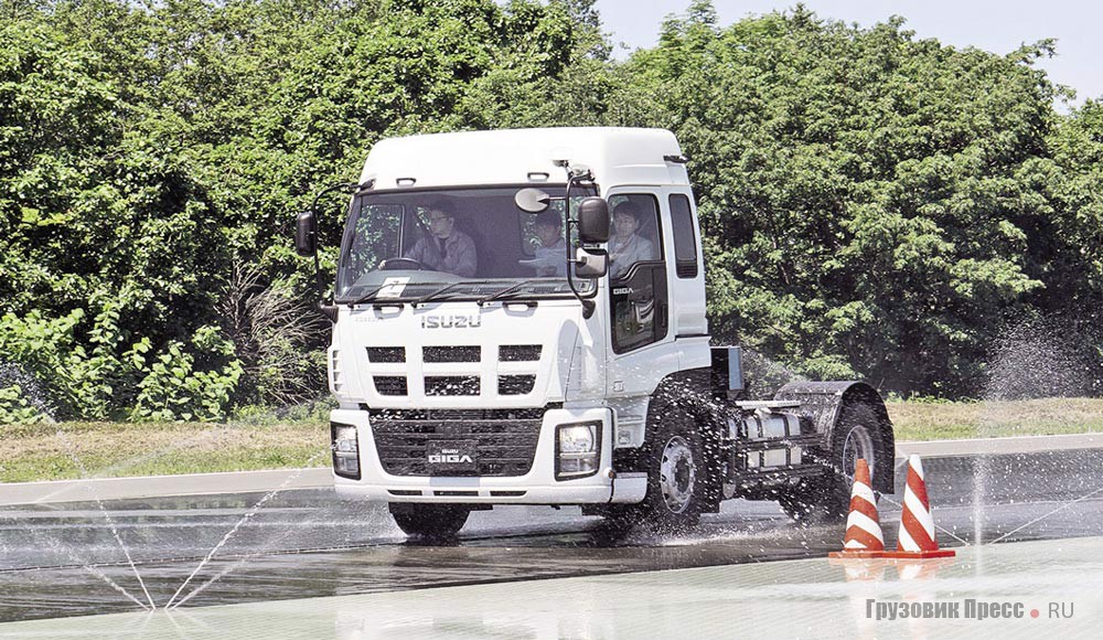 Isuzu Giga при демонстрации работы системы АБС на участке с базальтовым покрытием, обильно смоченным из сплинкеров водой