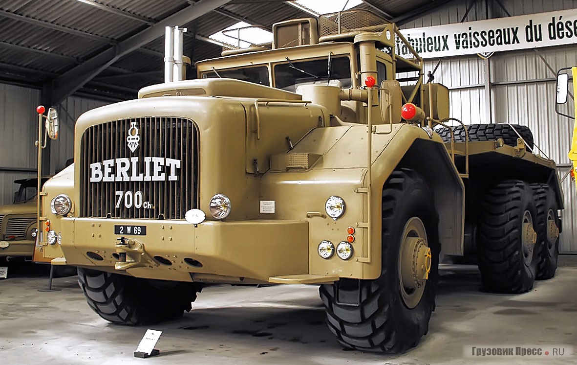 Самая известная и наиболее мощная модель французской марки – [b]Berliet T100[/b] образца 1957 г. Трёхосный (6х4) монстр габаритной длиной 13,4 м, шириной 5,5 м и высотой 4,5 м неспроста в пустынной окраске: его целенаправленно создали для освоения труднопроходимых районов Северной Африки. В частности, ему надлежало перевозить по зыбучим пескам нефтяные вышки, платформы, гидравлические буры и другое специальное оборудование. Отсюда и широкие пневматические шины с крупными шашками в рисунке протектора: они оказывали давление на грунт не больше, чем ступня верблюда. Число 700 на передке означает мощность мотора – 700 л.с. Но первоначально она была меньше: в носовой части устанавливали 30-литровый Cummins V12 с отдачей в 600 «сил», и весил подобный «толкач» ни много ни мало – 2,5 т. Всего было построено пять таких грузовиков. До наших дней «дожил» только один, выставленный в музее Berliet.<br />Обилие фар головного света на Berliet T100 сделано не для красоты, а для обеспечения хорошего освещения пути перед машиной. Угловые штанги с красными шарами на крыльях призваны обозначать габариты транспортного средства и помочь водителю при маневрировании. «По штату» каждому тяжеловозу полагался сервисный 5-тонный грузовик Berliet Gazelle, который перевозил полноразмерное запасное колесо, специальный домкрат, профессиональный инструмент и набор самых «ломких» запчастей