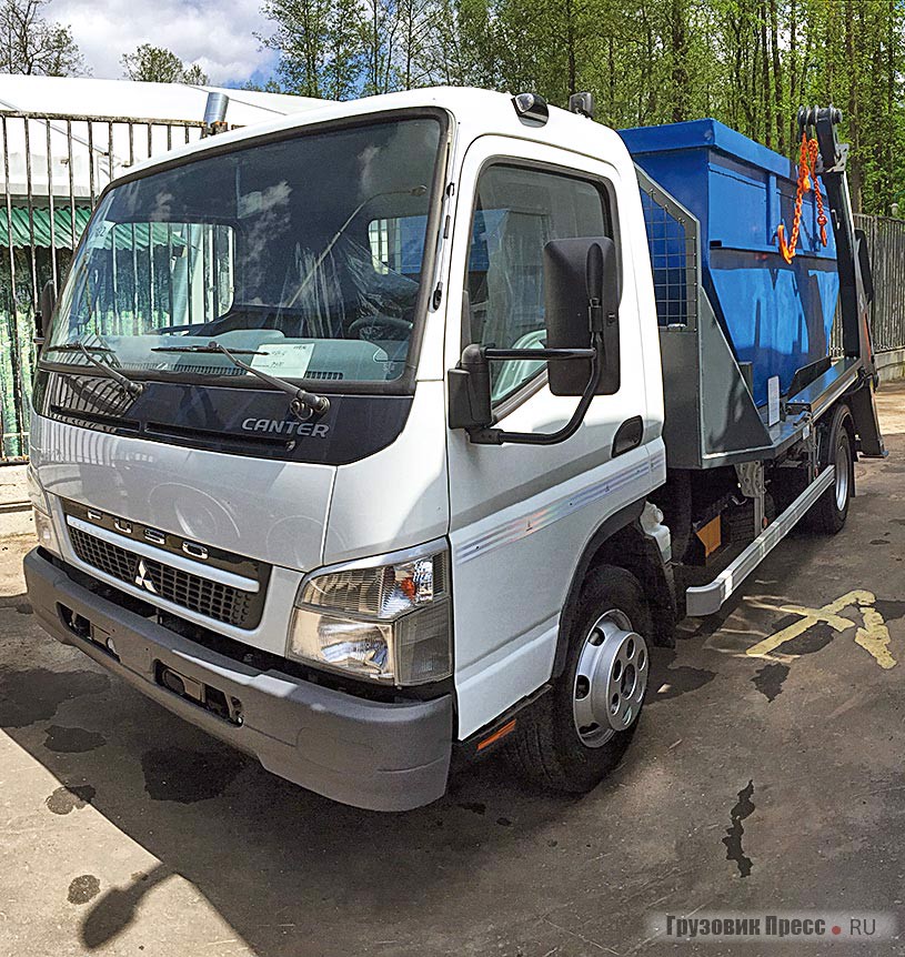 Самый маленький представитель экспозиции [b]Mitsubishi Fuso Canter[/b], оснащённый портальным погрузчиком и сменным накопителем типа «лодочка». Объём накопителя может быть от минимальных 5 м[sup]3[/sup], как здесь, до 15 м[sup]3[/sup], а грузоподъёмность портального погрузчика от 3,5 до 18 т. Используются такие устройства для вывоза строительного мусора на строительных объектах, но чаще при ремонте квартир и офисов