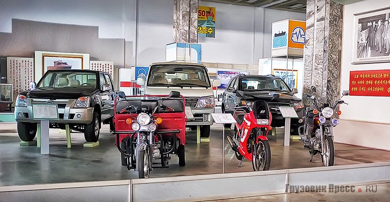 Экспозиция продукции завода Pyonghwa Auto Works из Нампо: заднеприводный пикап Ppeokpuggi III (Premio PU), выпускаемый с 2004 г. по лицензии Huanghai Shuguan, минивэн Samchonri, собираемый с 2005 г. из комплектов Brilliance Jinbei Awing, внедорожник Pyeonghwa Ppeokkugi 4WD CUV (Premio CUV) и  лицензионные китайские трициклы и мотоциклы
