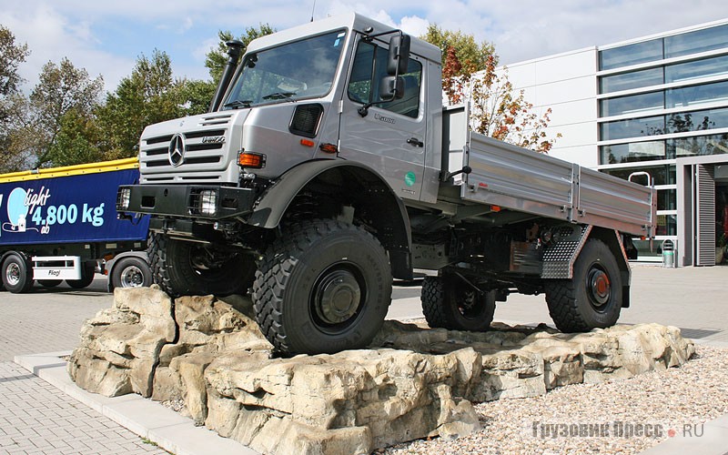 [b]Unimog U5000 (4х4), 2001 г.[/b] <br />Флагман серии 437,4, модель U5000 с металлической бортовой платформой фирмы Empl из Кальтенбаха (Австрия). Габариты: 6010х2340х2830 мм, колесная база 3850 мм, кузов длиной 4100 мм, колея 1926 мм. Дорожный просвет 480 мм, угол въезда 48°, угол съезда 54°. Диаметр разворота 16,5 м. Представлен на выставке IAA в Ганновере. Оснащен 4-цилиндровым рядным двигателем Mercedes-Benz OM 924 LA рабочим объемом 4801 см[sup]3[/sup] и мощностью 218 л.с./ 160 кВт. Собственная масса 5300 кг, допустимая полная – 14 100 кг.