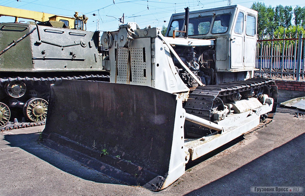 [b]Бульдозер неповоротного типа с канатно-блочным управлением Д-271[/b] на тракторе С-100. Это последний трактор в СССР, названный в честь Сталина. С 1956 по 1964 год выпущено 124 416 машин. У экспоната – кабина от более позднего Т-100М. В обоих случаях 100 – это мощность дизеля в л.с. Эксплуатационная масса трактора 11 100 кг. Хорошо видна рукоятка пускача