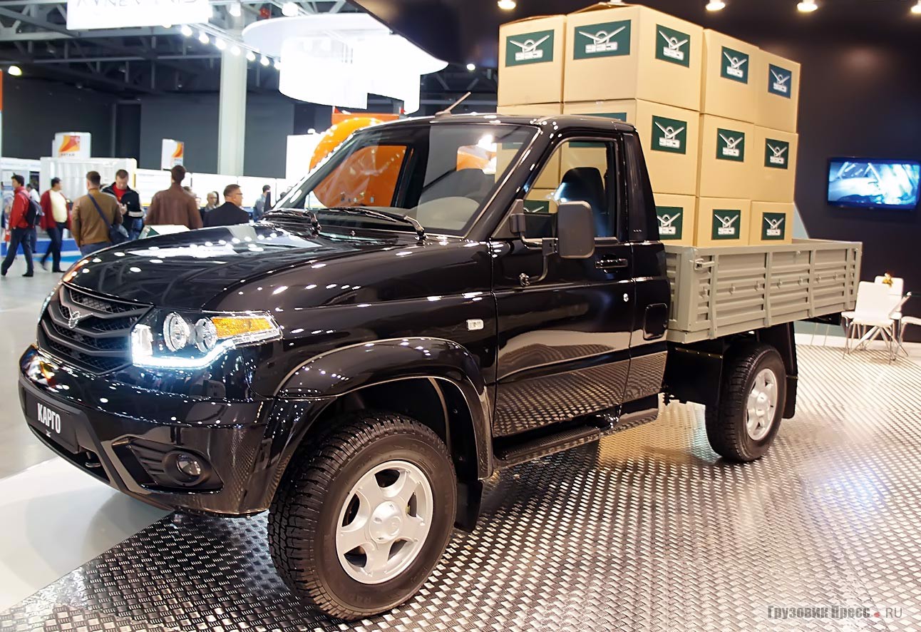 [b]UAZ Cargo[/b] 2015 модельного года. Его отличительные черты – новый ГУР, необслуживаемые карданы, фары со встроенными дневными ходовыми огнями, более крупные «противотуманки». Увы, вместо «шайбы» электрического управления «раздаткой» как в пикапе, здесь по-прежнему рычаги в полу. А окраску для «работяги» я бы предпочел попроще…