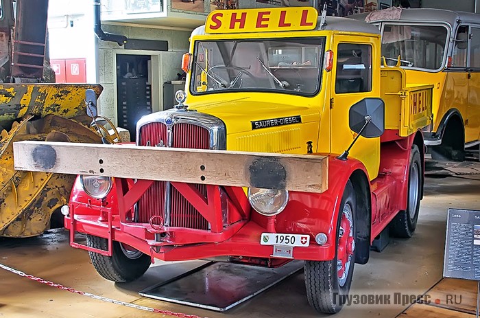 Промышленный тягач [b]Saurer 2CR1D[/b], 1948 г. Использовался в качестве маневрового локомотива компанией по продаже нефтепродуктов Lumina AG, в 1949 г. поглощённой корпорацией Shell. Оснащён рядным 5,32-литровым четырёхцилиндровым дизелем мощностью 75 л.с. Скорость – 45 км/ч.