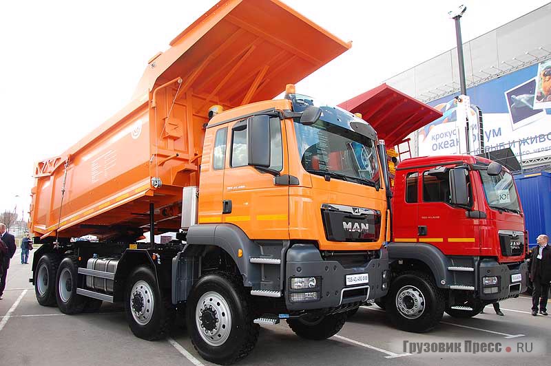 MAN TGS 41.440 8x4 BB-WW c кузовом БЦМ-59.6 «Бецема Формат Уголь» (красный самосвал) и MAN TGS 41.480 8х8 BB-WW c кузовом БЦМ-59.6 «Бецема Формат Скала» (оранжевый самосвал)