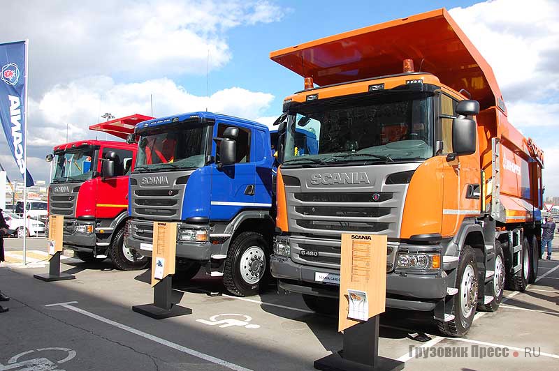 Слева на право: углевоз Scania G440 CB8x4EHZ с кузовом Wielton (красный самосвал) и две машины с кузовами KH-Kipper: полноприводный Scania G480 CB8x8EHZ (синий самосвал) для транспортировки инертных материалов и Scania G480 CB8x4EHZ для скальных пород (оранжевый самосвал)